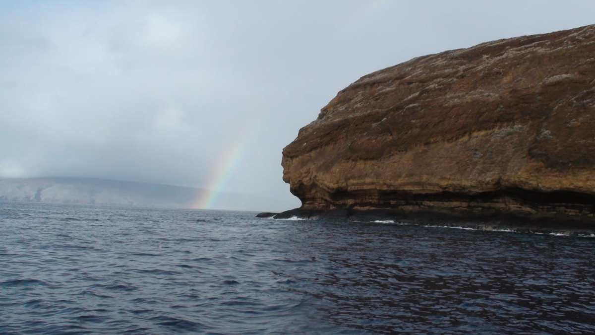 Backwall-Molokini-Rainbow a large body of water with a mountain in the background