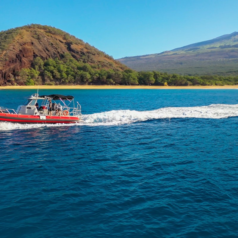 a small boat in a body of water with a mountain in the background