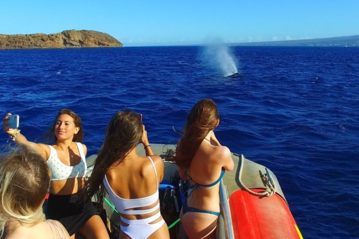 a group of people standing in front of a body of water