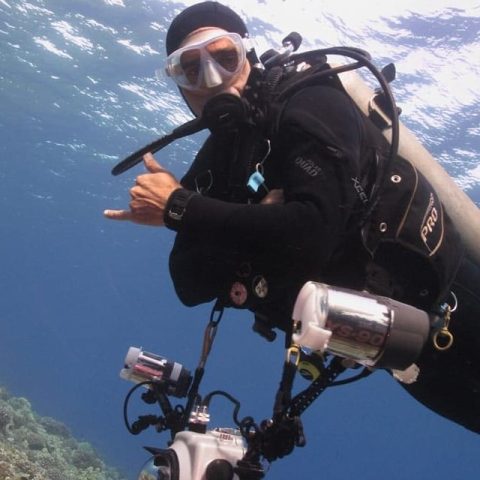 a man flying through the air while swimming in a body of water