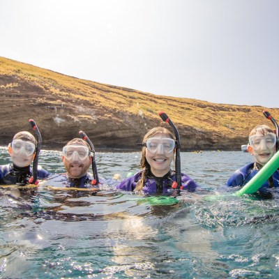 A family snorkeling at Molokini Crater in Maui, Hawaii.